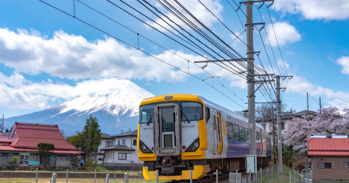 A train passing below Mt. Fuji in spring