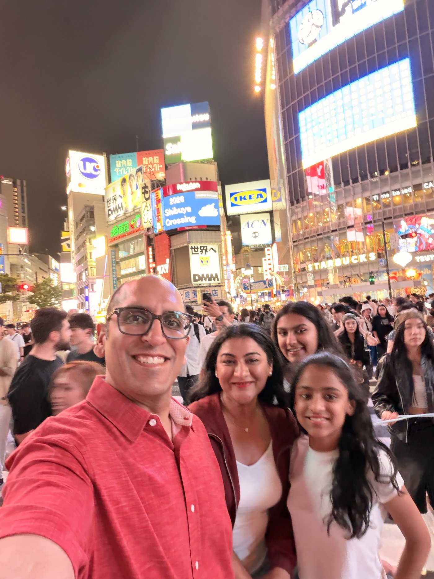 A family selfie in the neon crowds of Shibuya at night